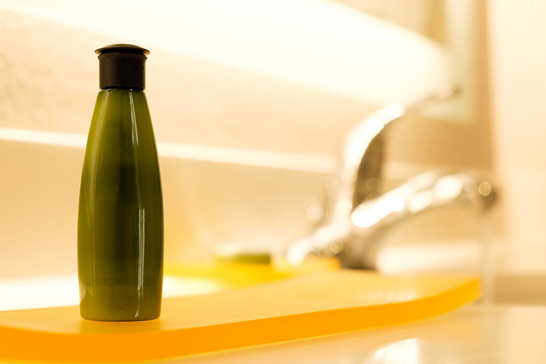 Green small cosmestic container lotion, shampoo or body gel in bathroom